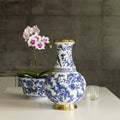 Front view of blue and white porcelain vase with gold base on table