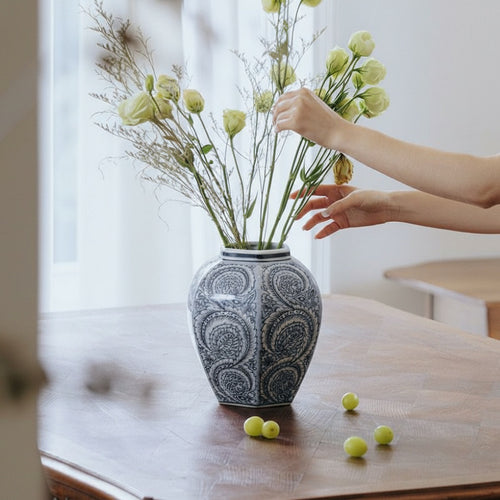 Blue and white porcelain hexagonal ginger jar holding flowers on table