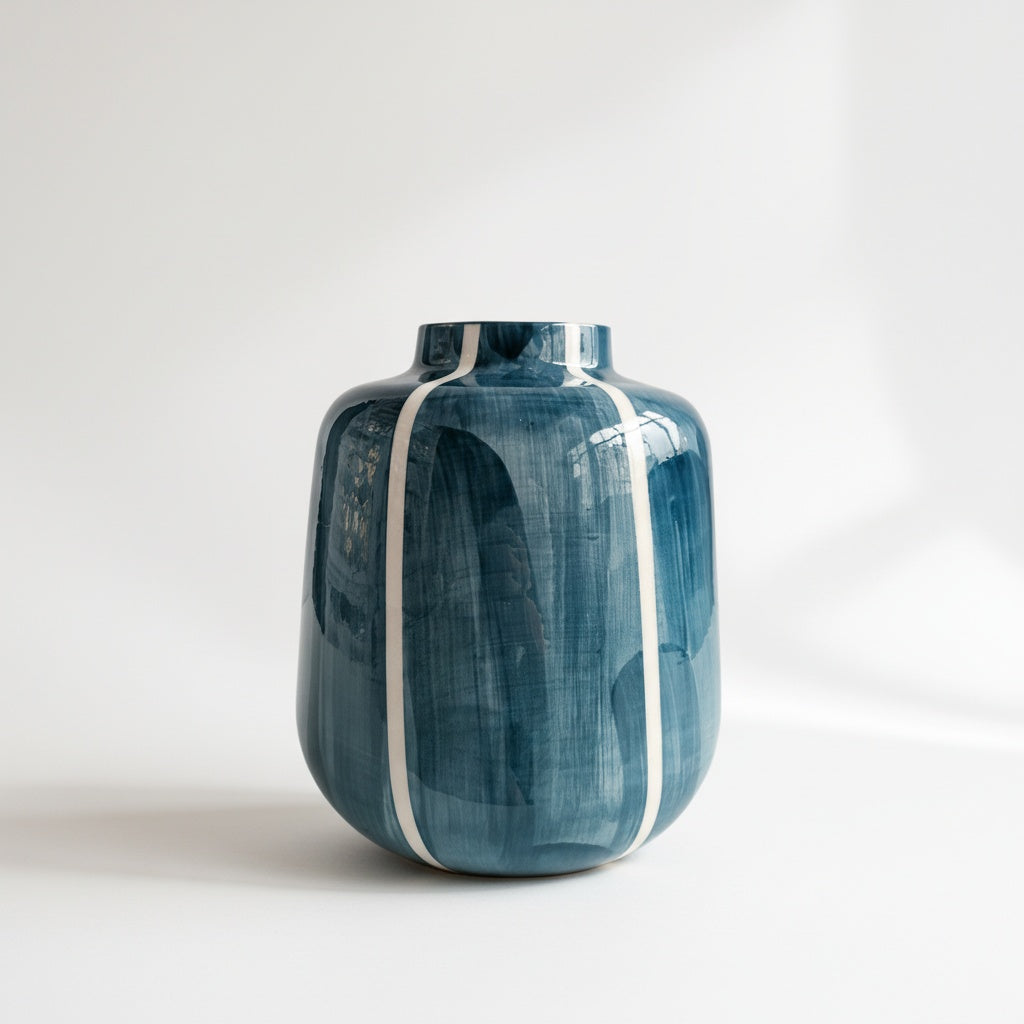 Detail of empty blue and white striped fluted ceramic vase