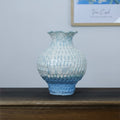 Blue and white gradient ceramic vase with textured surface on table