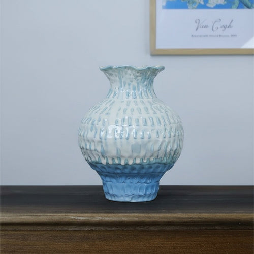 Blue and white gradient ceramic vase with textured surface on table