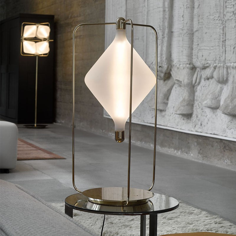 Brass alloy table lamp with suspended diamond shade in modern loft setting