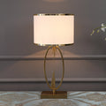Front view of brass oval table lamp with lit shade