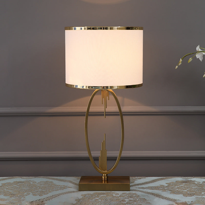 Front view of brass oval table lamp with lit shade