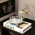 Front view of brass and crystal bird decorative bowl on books