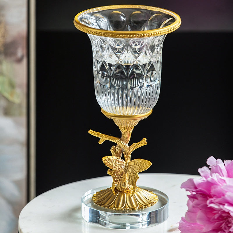 Close up of crystal vase on brass butterfly stand