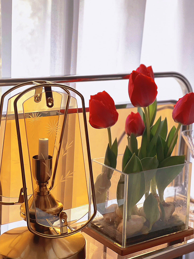 Detail of lamp next to red tulips