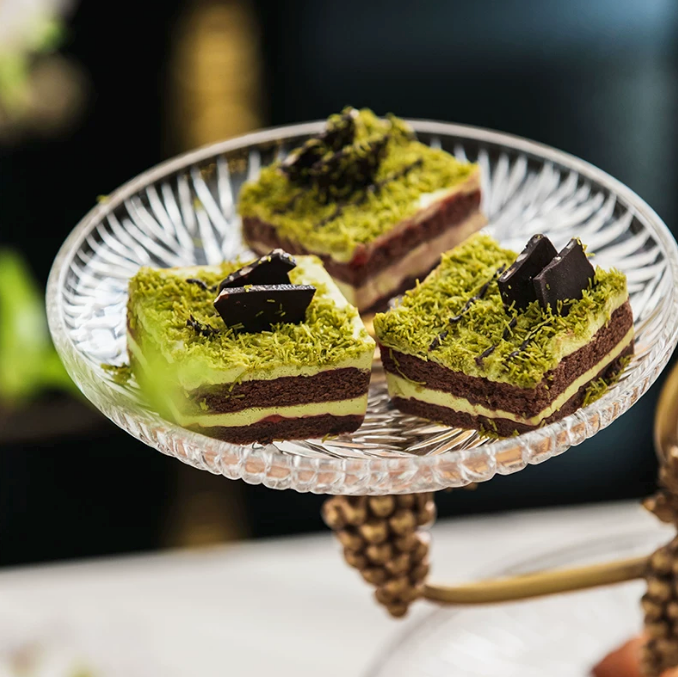 Glass dessert tray on brass grapevine serving stand with cake slices