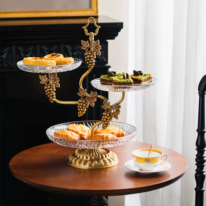 Brass and glass grapevine dessert stand with pastries on round table