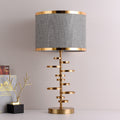 Front view of the brass and grey fabric table lamp