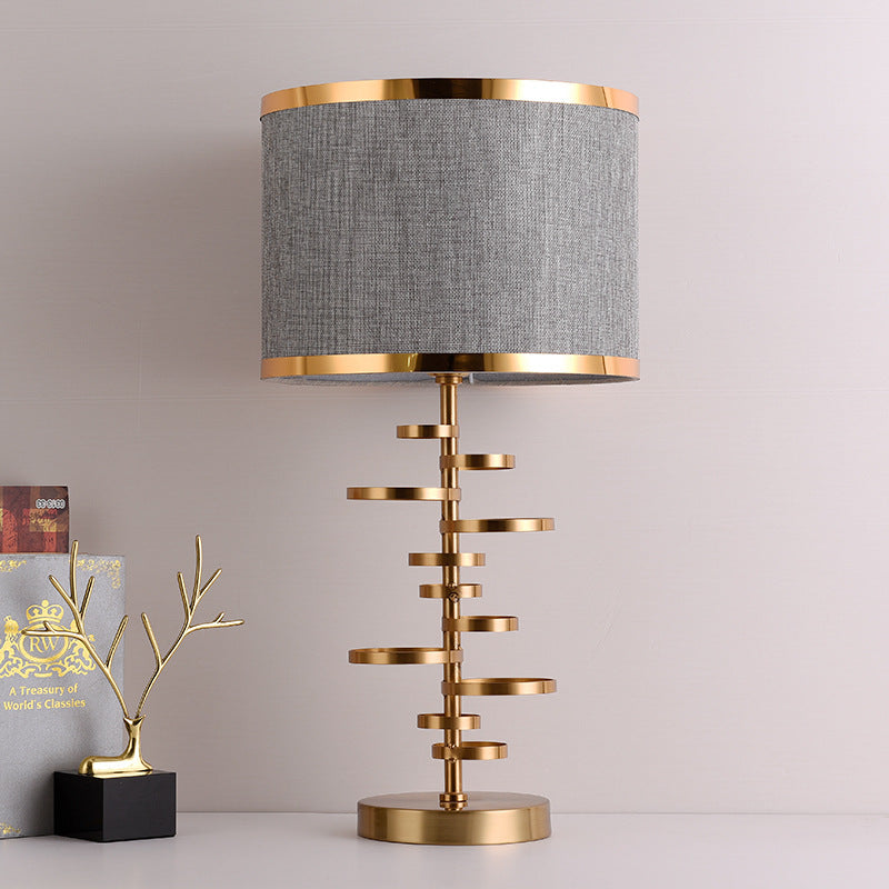 Front view of the brass and grey fabric table lamp