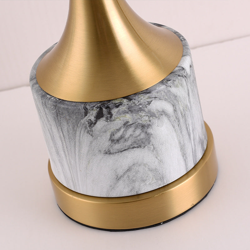 Detail of white marble base and brass stem connection