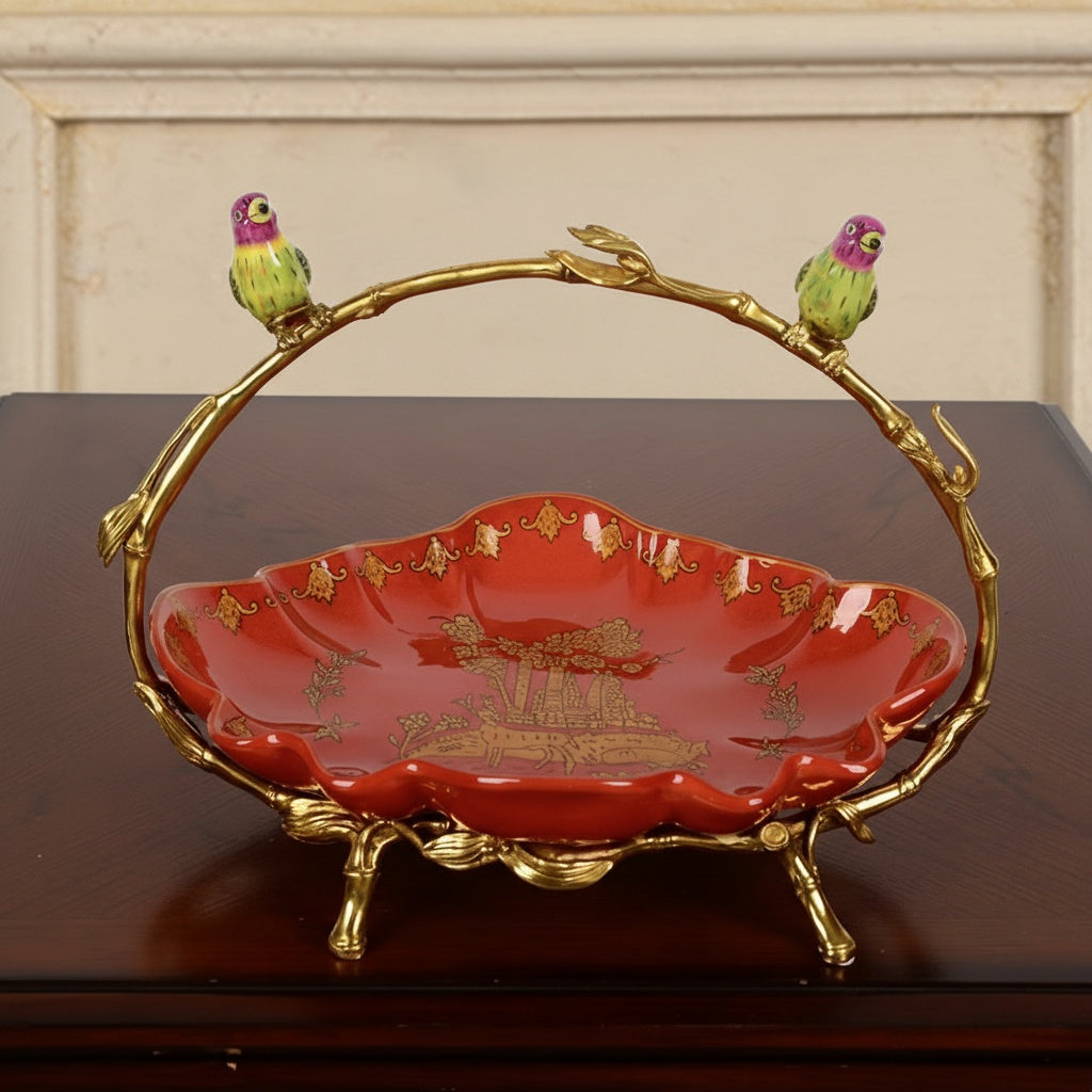 Front view of red porcelain bowl with brass branch handle and birds