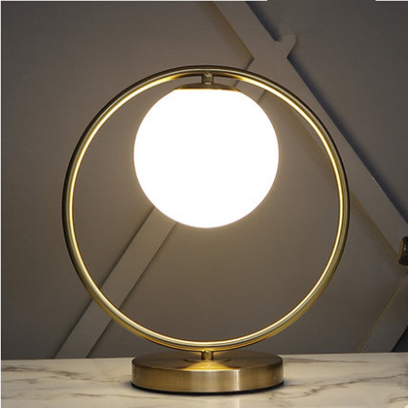 Front view of brass circle lamp with white glass sphere