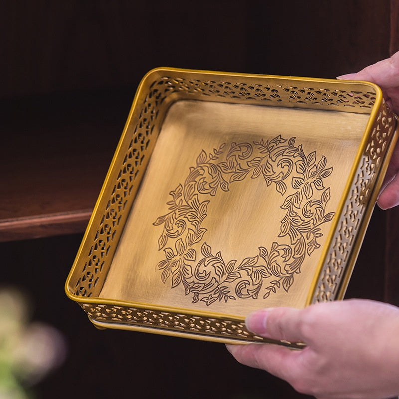 Detail of engraved floral design on interior of brass tray