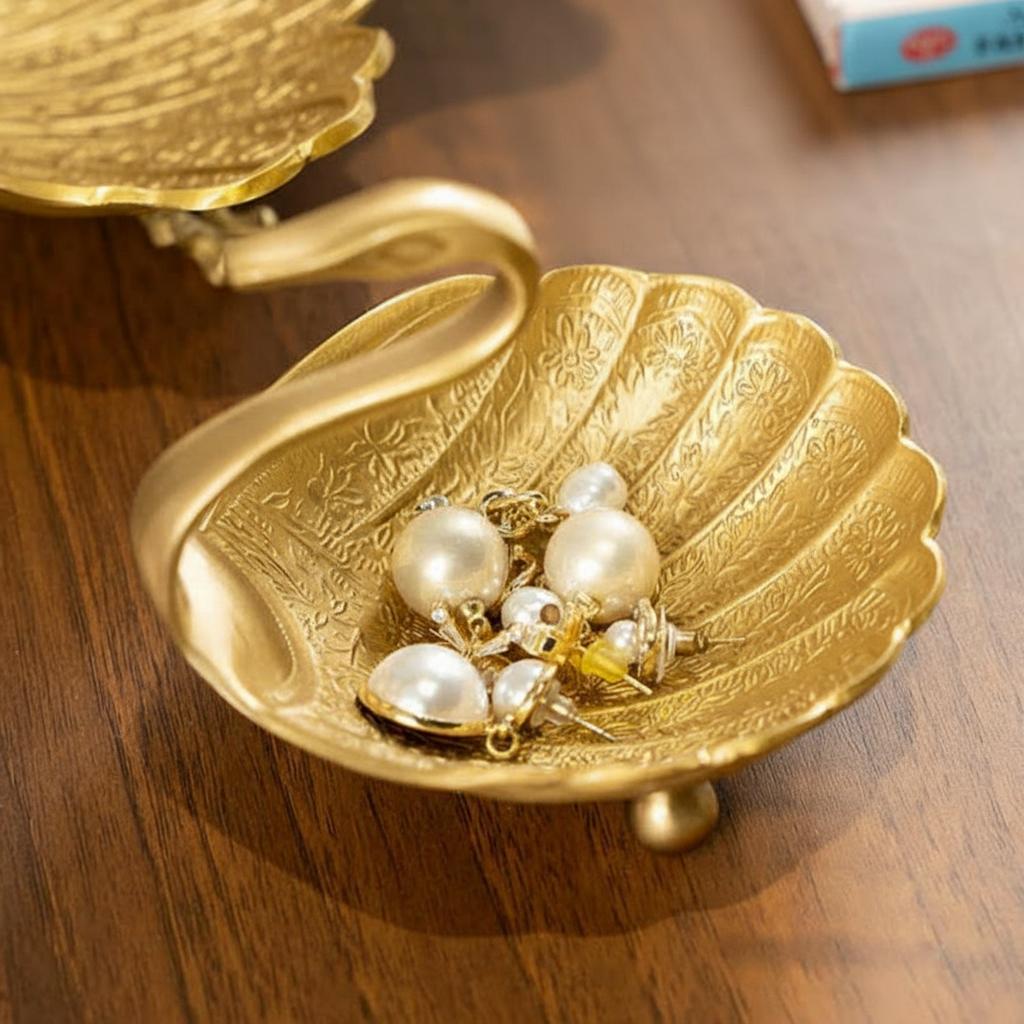 Small brass swan trinket dish holding pearl earrings