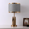 Front view of brass vertical rod table lamp with grey shade
