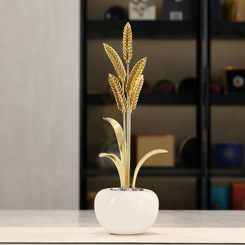Gold brass wheat decor on white base in shelf setting