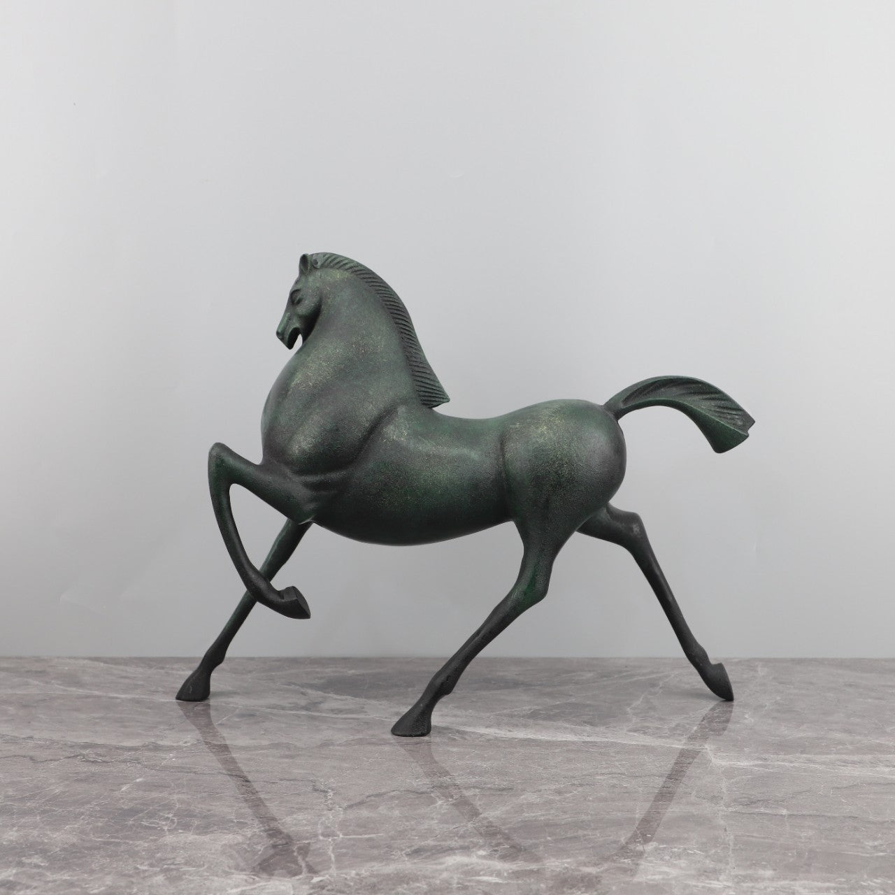 Side profile view of antique bronze finish prancing horse sculpture