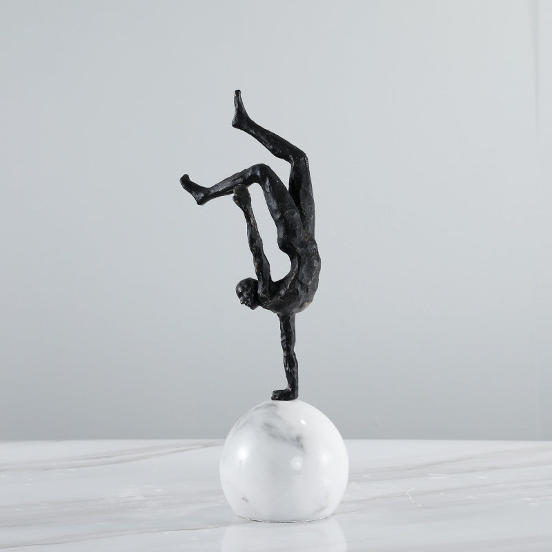 Front view of bronze finish acrobat sculpture on white marble base