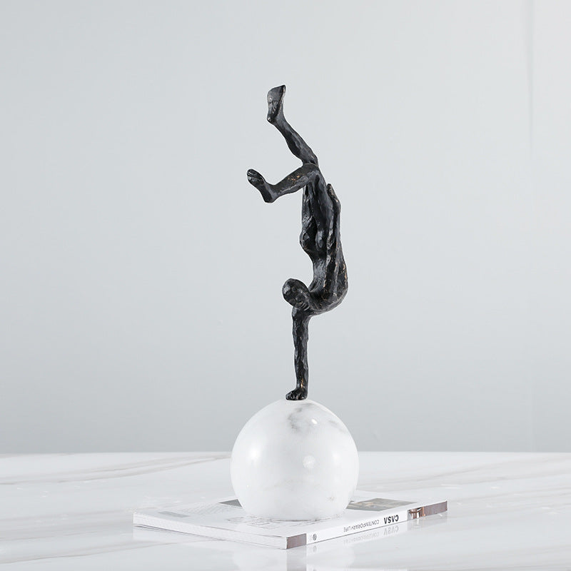 Angled view of handstand sculpture on marble table