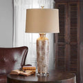 Front view of bronze snakeskin ceramic table lamp lit