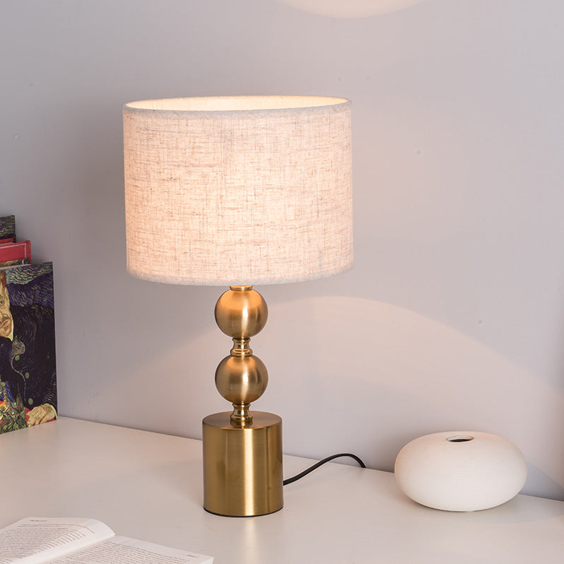 Angled view of gold geometric table lamp with warm lighting