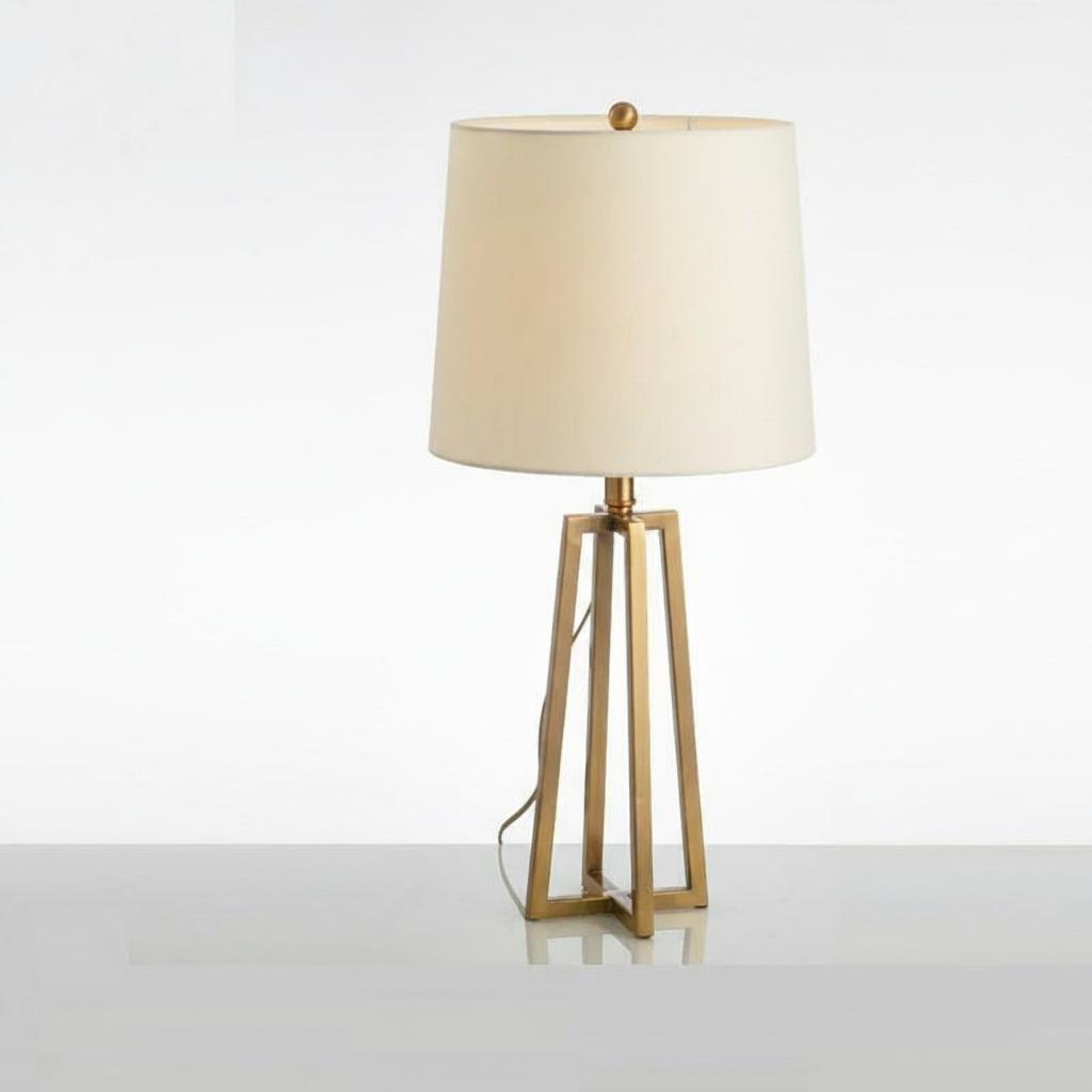 Front view of brushed brass geometric table lamp with cream shade