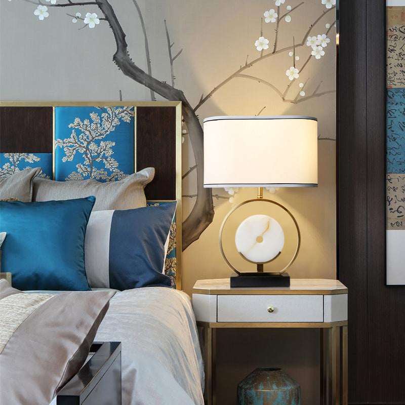 Lifestyle shot of brass ring lamp on bedside table in luxury bedroom