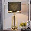 Front view of brushed brass table lamp with black shade