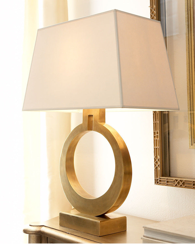 Lifestyle view of brass ring lamp on side table