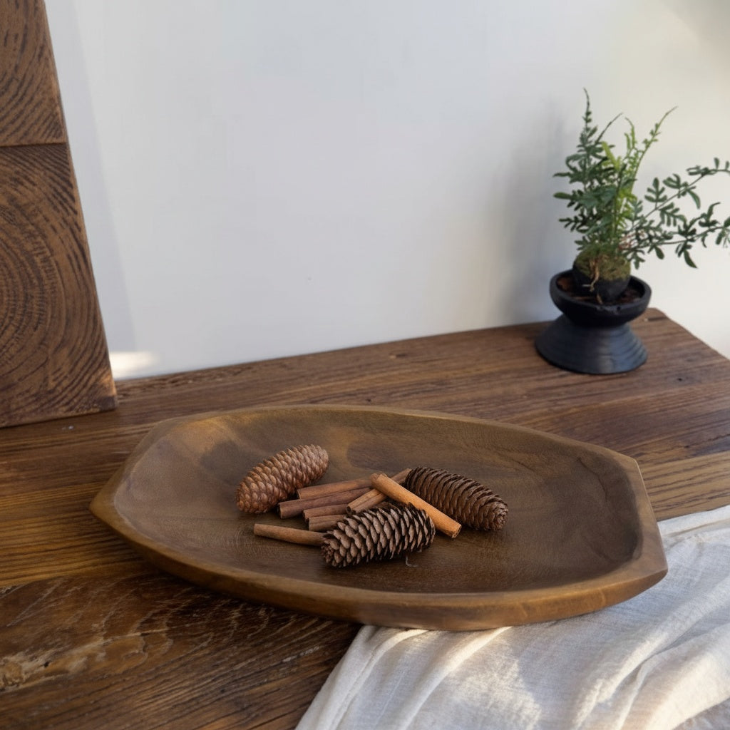 Carved wood elongated centerpiece bowl displaying pinecones and cinnamon