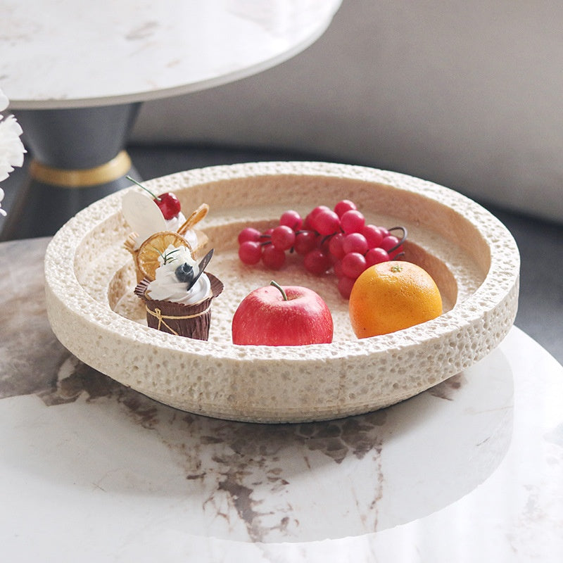 Angled view of beige porous stone serving bowl