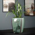 Celadon ceramic planter with orchids front view