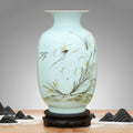 Front view of celadon vase with floral relief on wooden stand