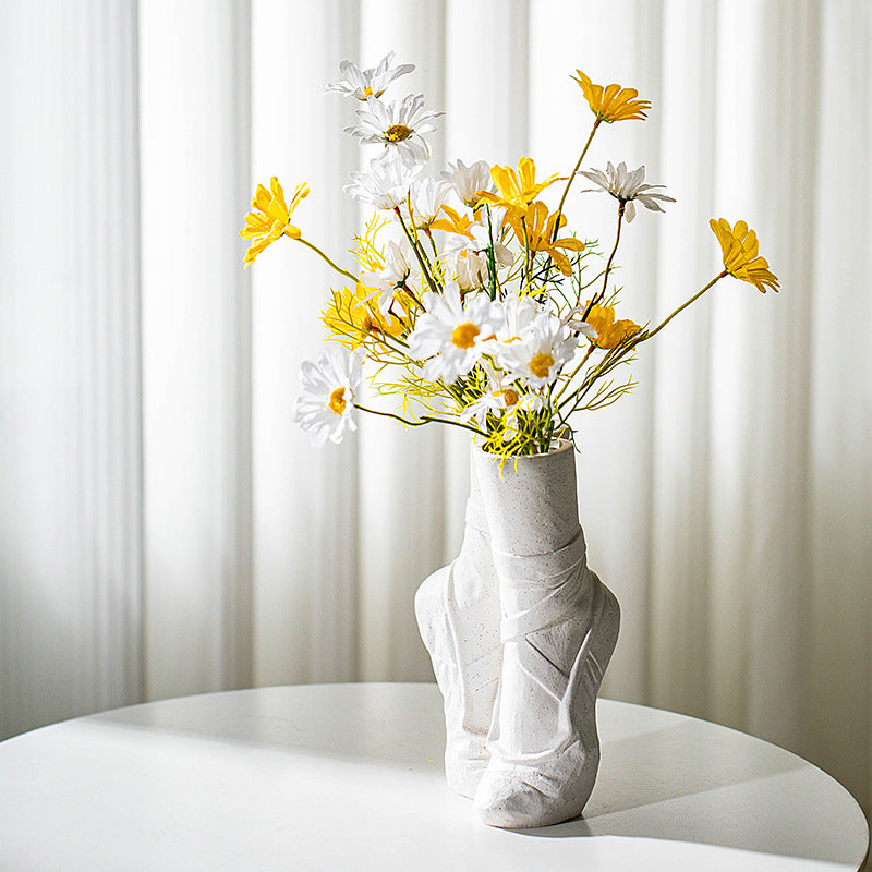 White ceramic ballet vase with yellow and white daisies