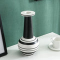 Black and white striped ceramic vase with tall neck