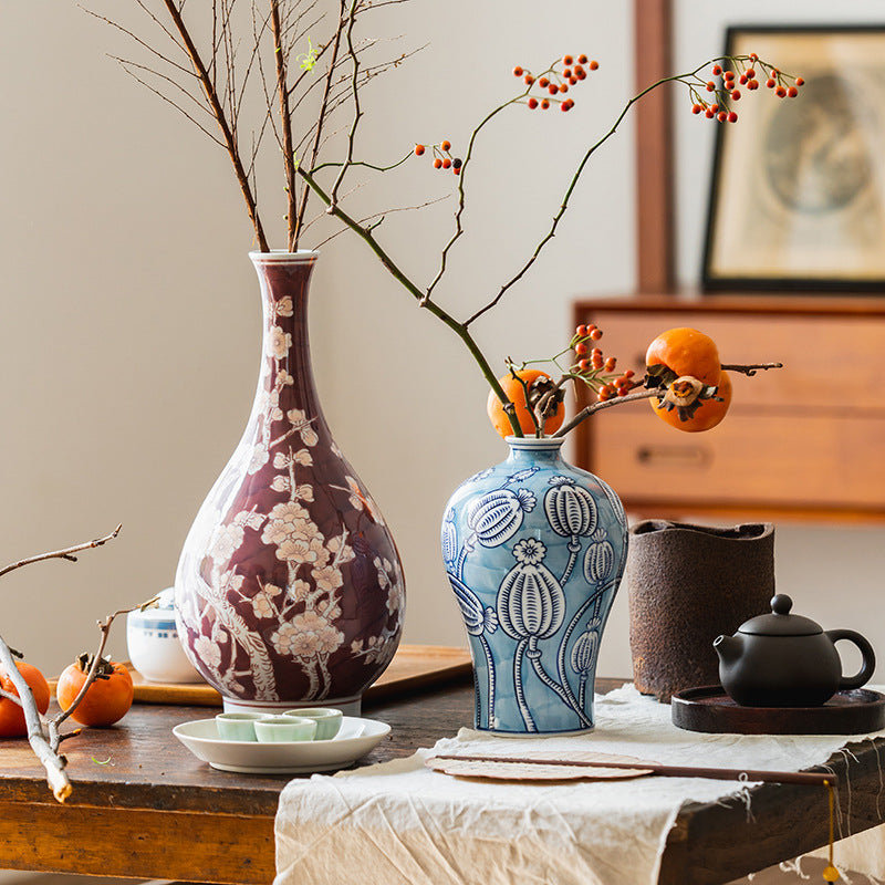 Two hand painted ceramic vases on rustic wooden table with branches