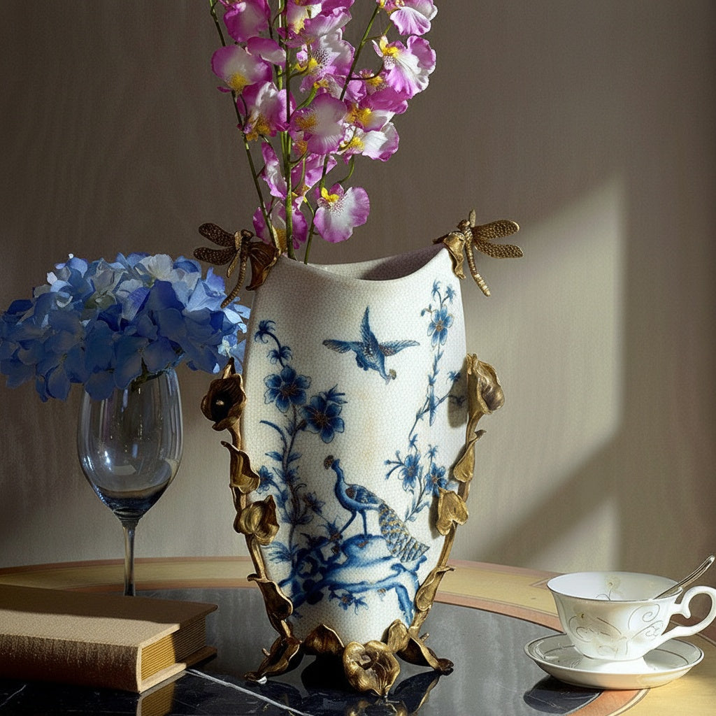 Ceramic vase featuring blue floral painting and brass vine accents