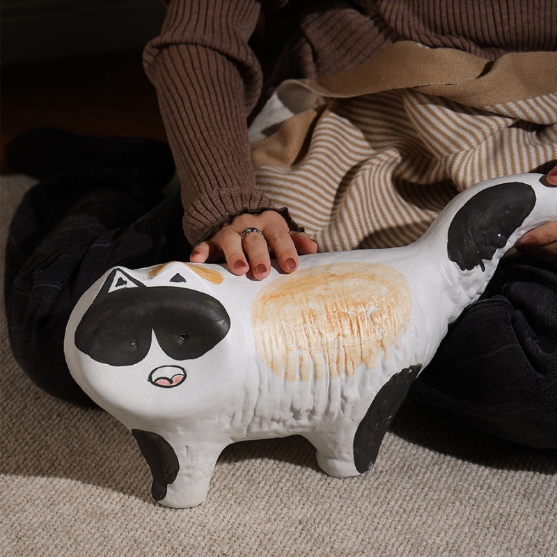 Lifestyle shot of ceramic cat figurine being held