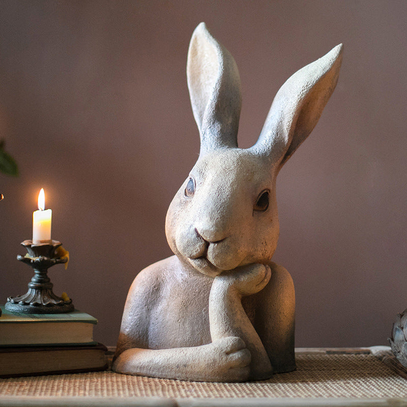Angled view of contemplative rabbit bust with candlelight