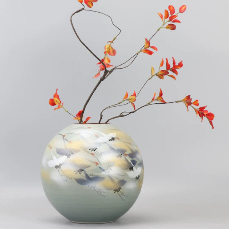 Front view of spherical ceramic vase with painted crane motif