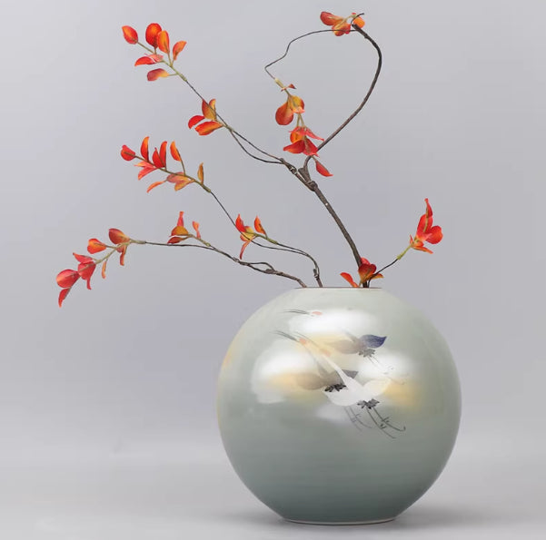 Angled view of round ceramic vase showing glazed finish and art details