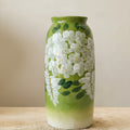 Close up of green ceramic vase with white flowers
