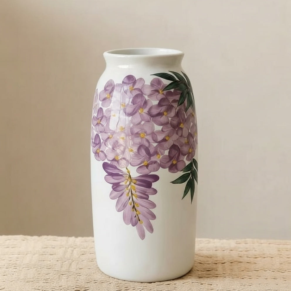Close up of white ceramic vase with purple wisteria design