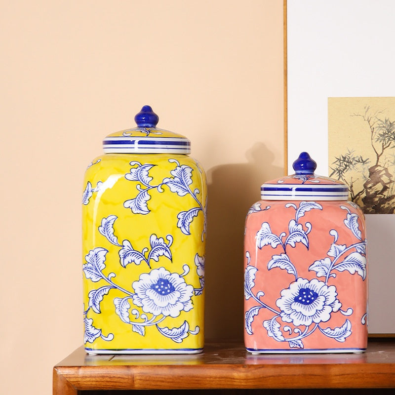 Two ceramic floral ginger jars in yellow and pink side by side