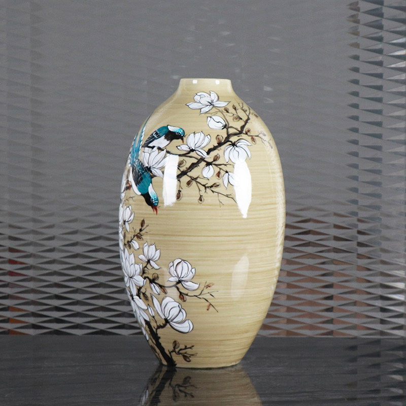 Angled view of ceramic vase showing detailed bird and flower painting