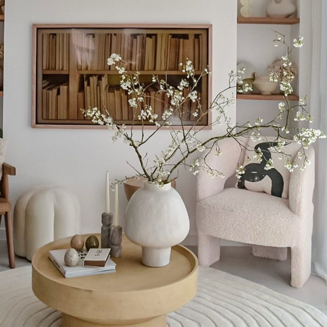 Organic white ceramic vase styled with branches on coffee table
