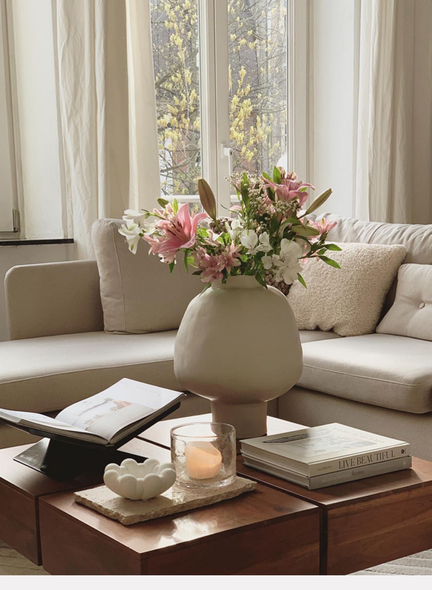 Matte white bulbous vase with pink flowers in living room