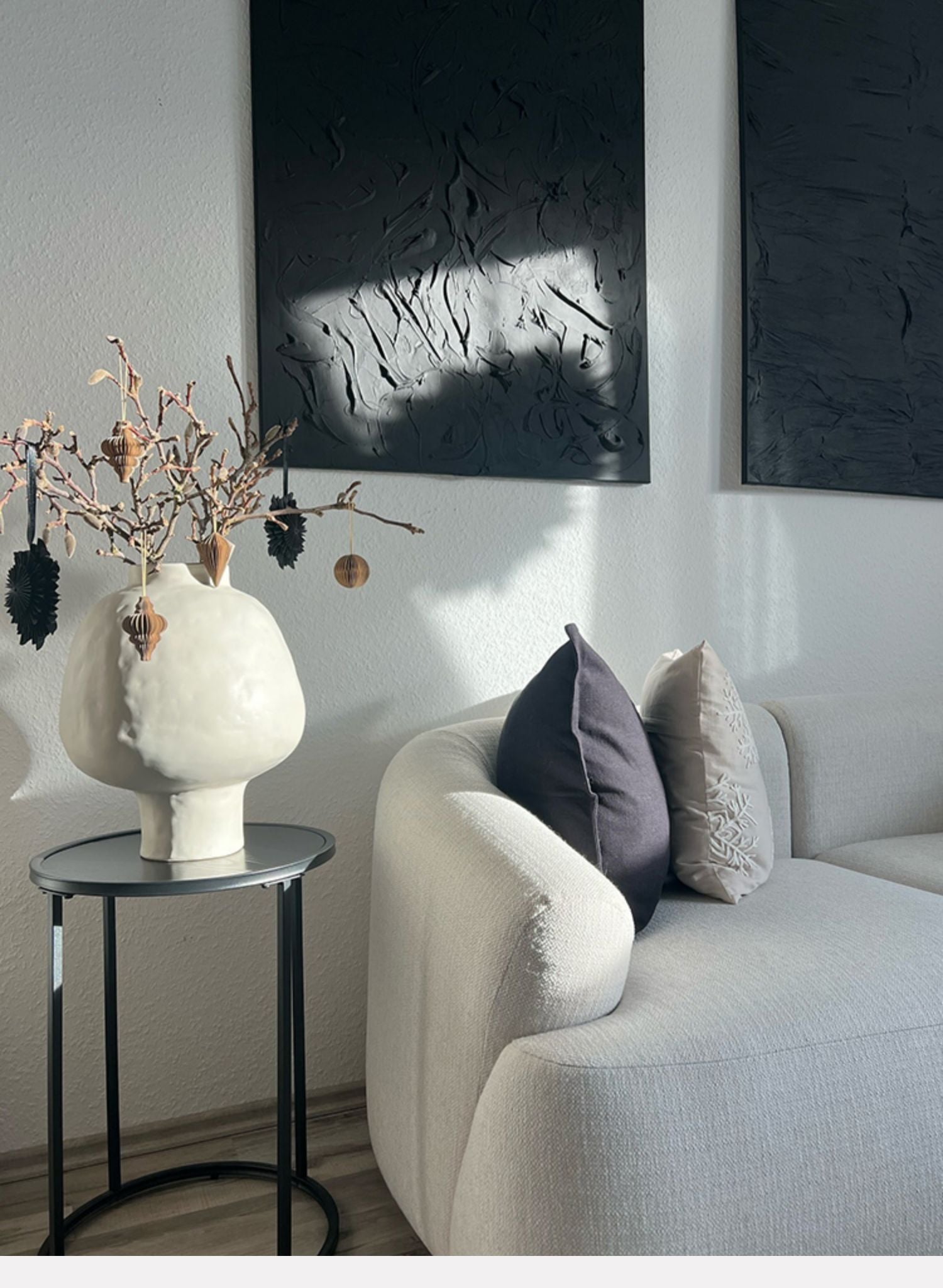 Sculptural white vase with seasonal ornaments on side table